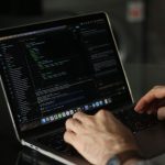 Developer working on web development project ideas on laptop