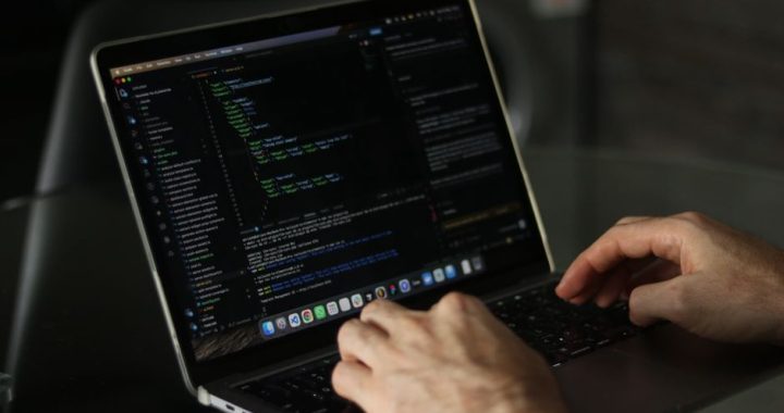 Developer working on web development project ideas on laptop