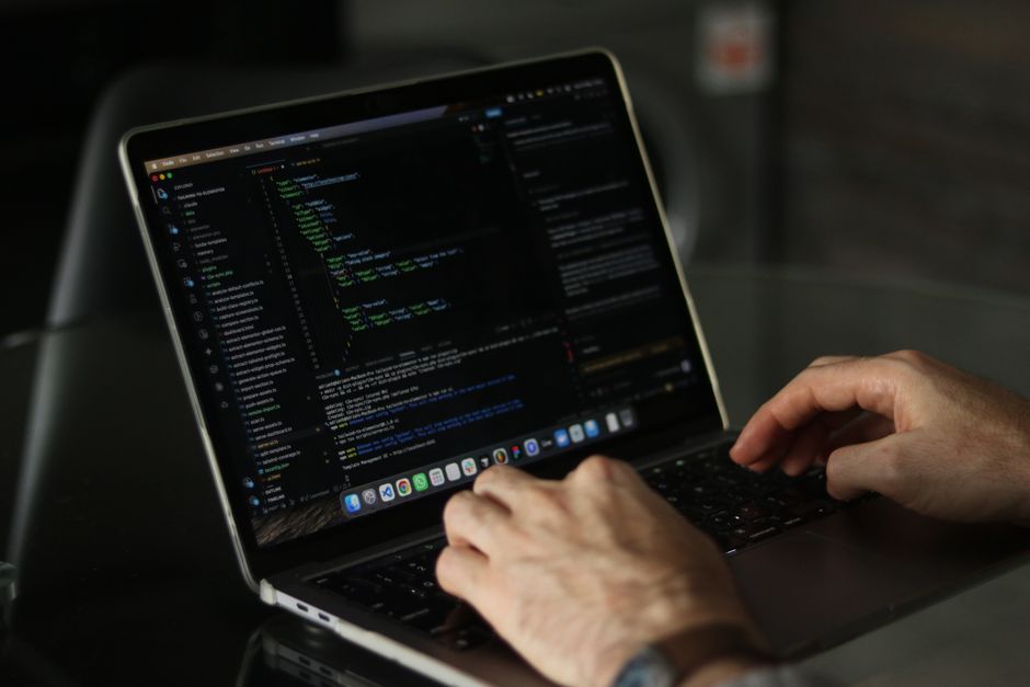 Developer working on web development project ideas on laptop