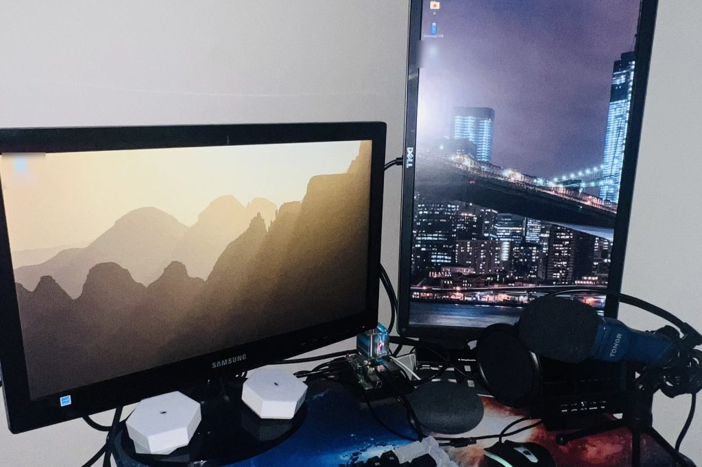 Two monitors showing the Raspberry Pi OS desktop, with the Raspberry Pi 4 that runs this website between them