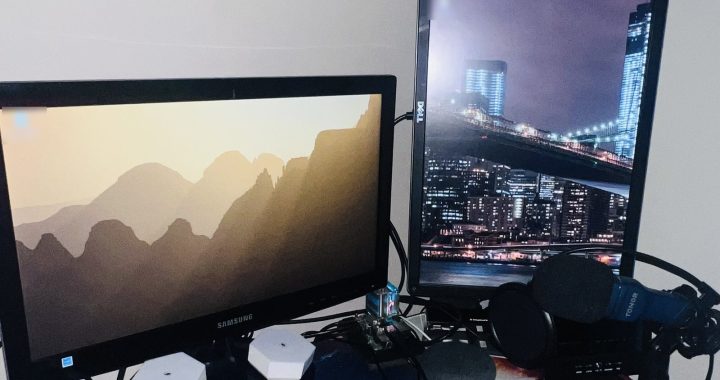 Two monitors showing the Raspberry Pi OS desktop, with the Raspberry Pi 4 that runs this website between them